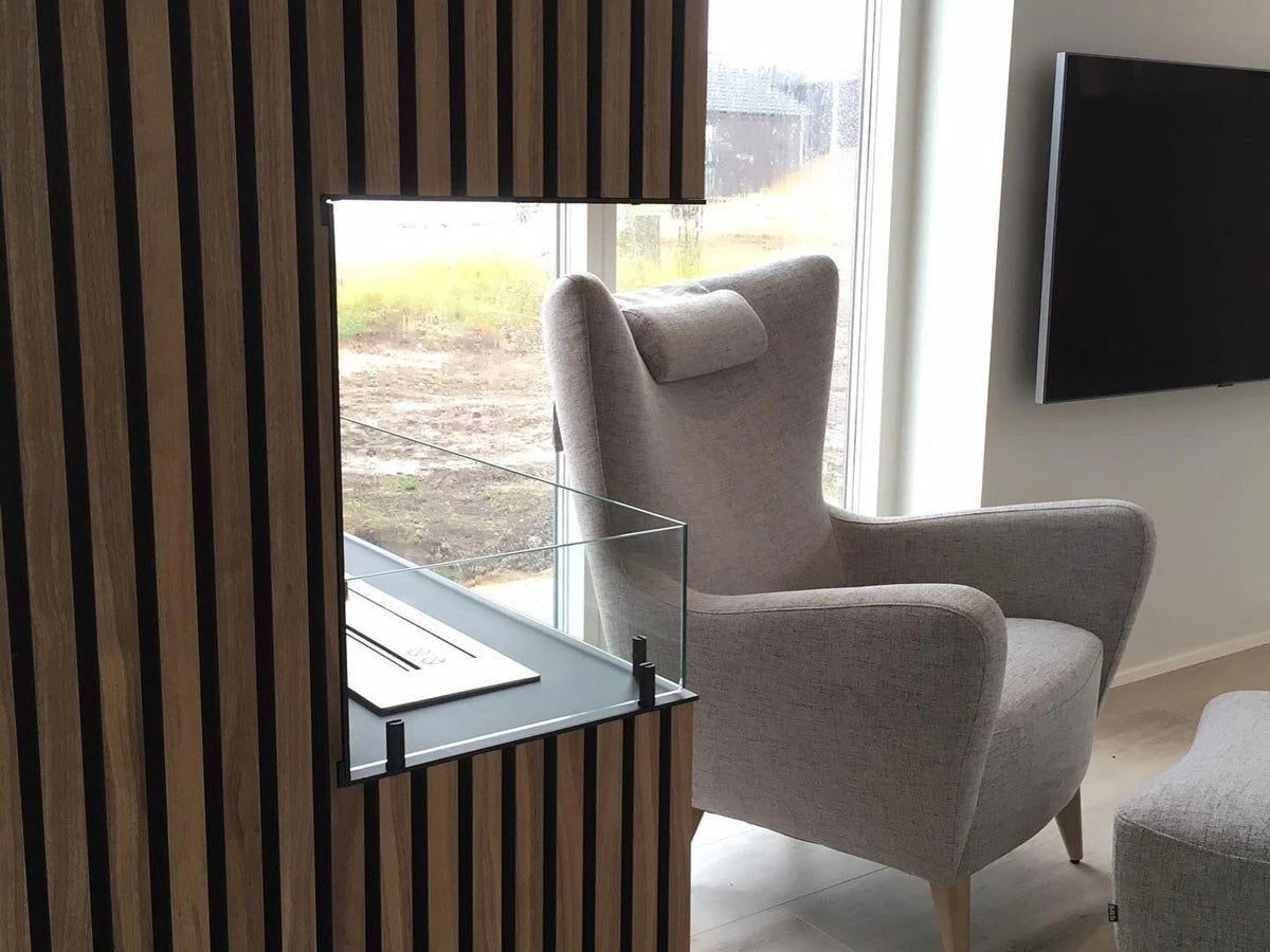 Foco Corner Left 800 in a wood-slat room divider beside a wingback armchair, flame off