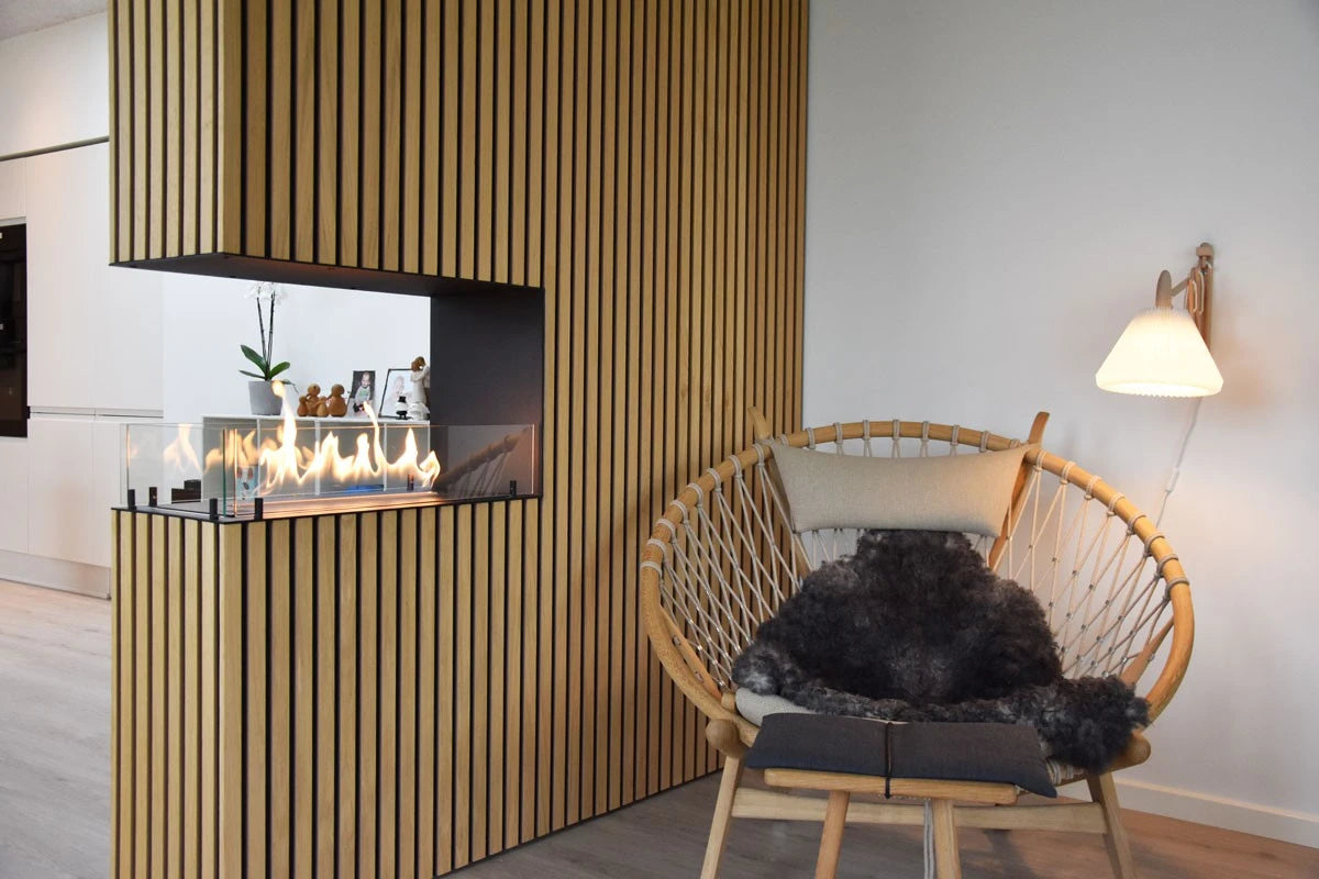 Foco Room Divider 800 installed in a cozy Scandinavian living room with wood-slat surround and lit ethanol flame