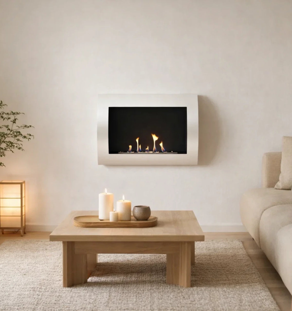 Ocean white bioethanol wall-mounted fireplace with lit flame, styled above a wooden coffee table with candles in a bright living room