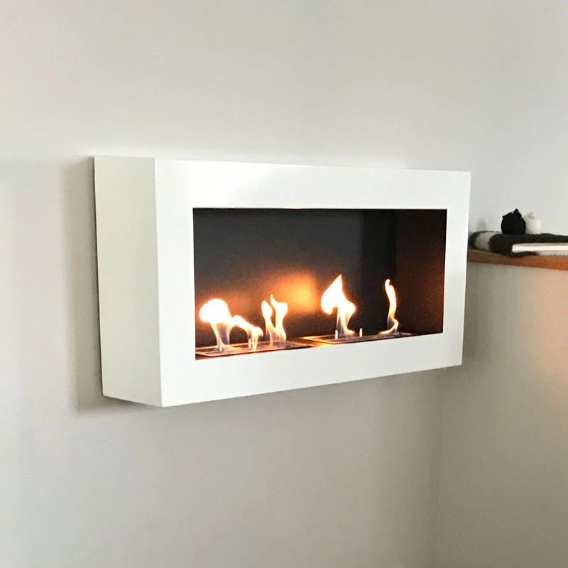 Large white bioethanol fireplace mounted on a wall with lit flames, genuine customer install photo beside a wooden shelf