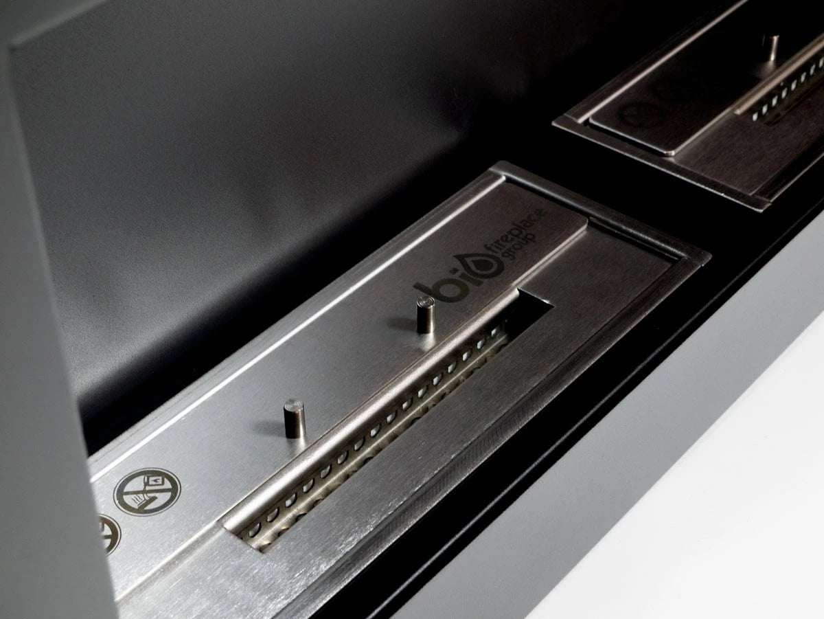 Close-up of the large black bio fireplace's stainless steel burner trays
