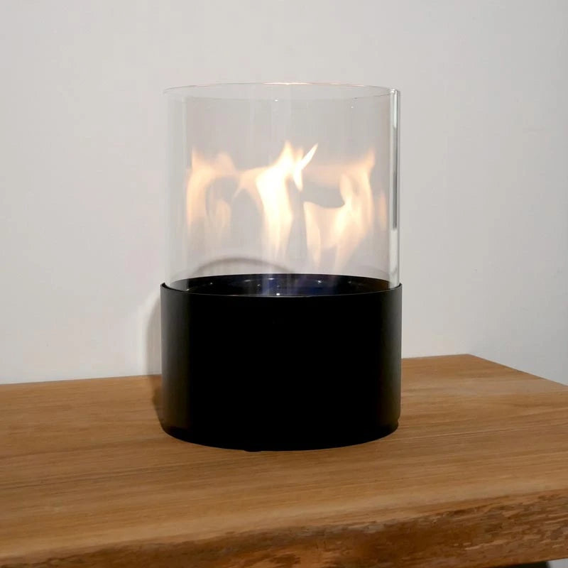 Close-up of the Kennington fireplace's lit flame, angled view, on a wooden table