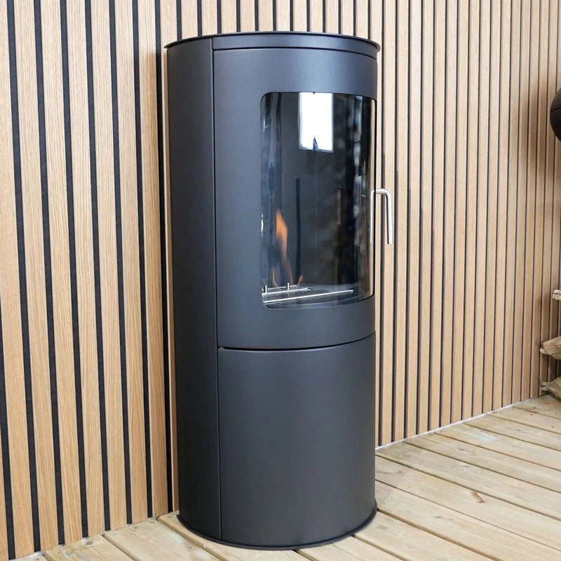 Richmond bioethanol fire stove against a wood-slat wall, angled view, lit flame