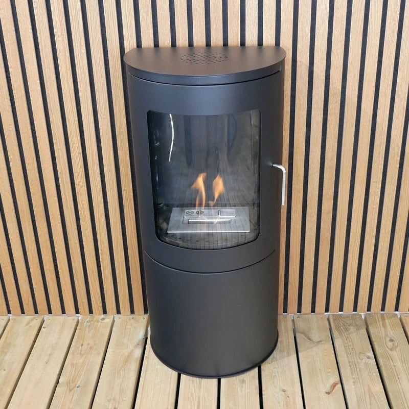 Richmond bioethanol fire stove with flat back against a wood-slat wall, lit flame