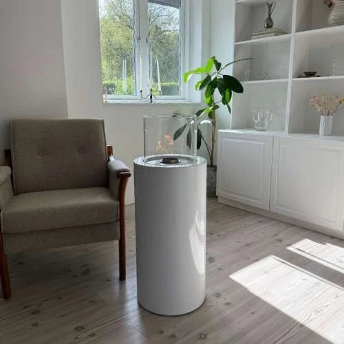ScandiFlames Dualis White floor-standing bioethanol fireplace with a lit flame in a bright living room with built-in white shelving