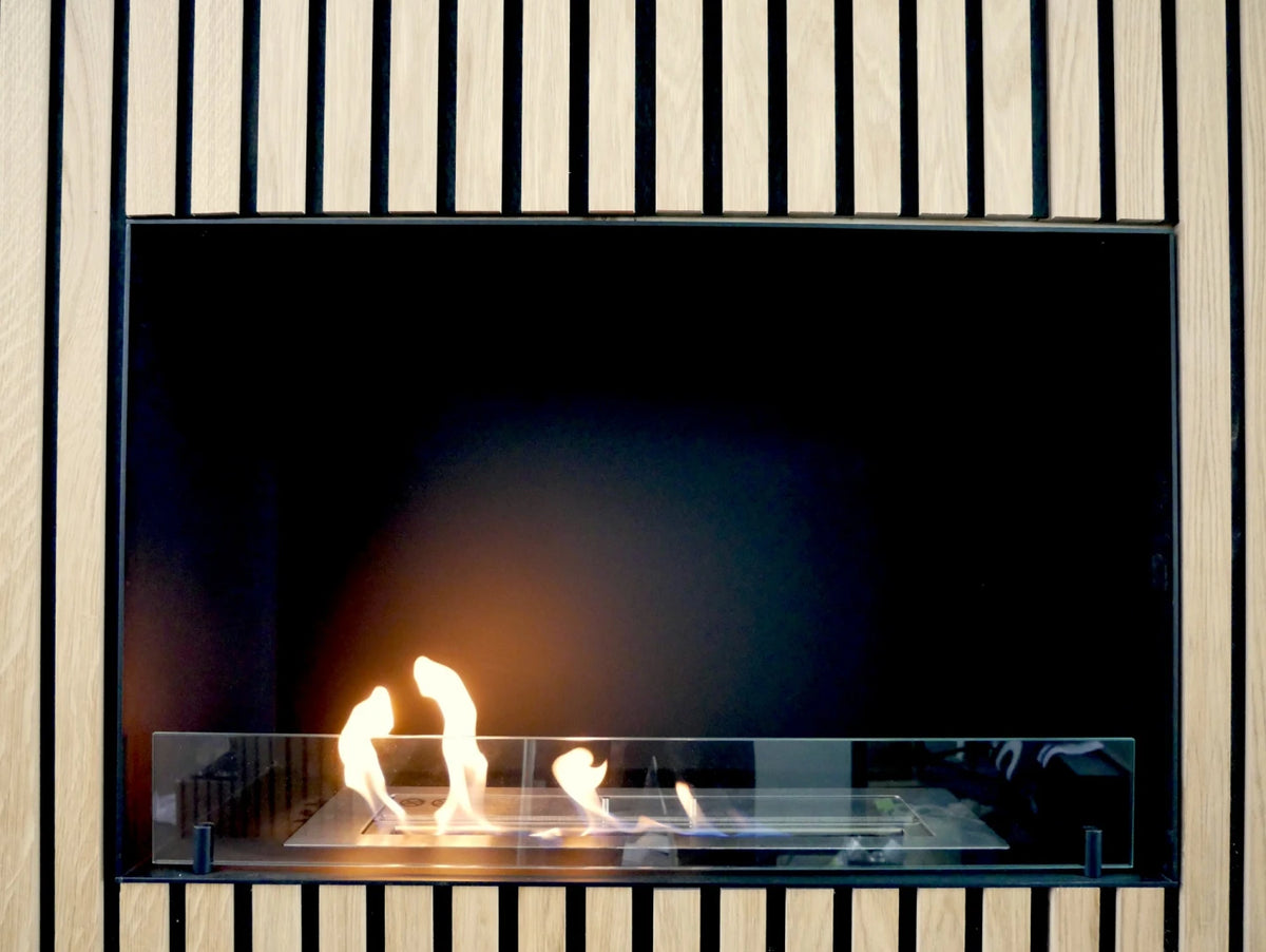 Foco One 800 built into a light oak wood-slat wall with a lit flame, trade showroom photo