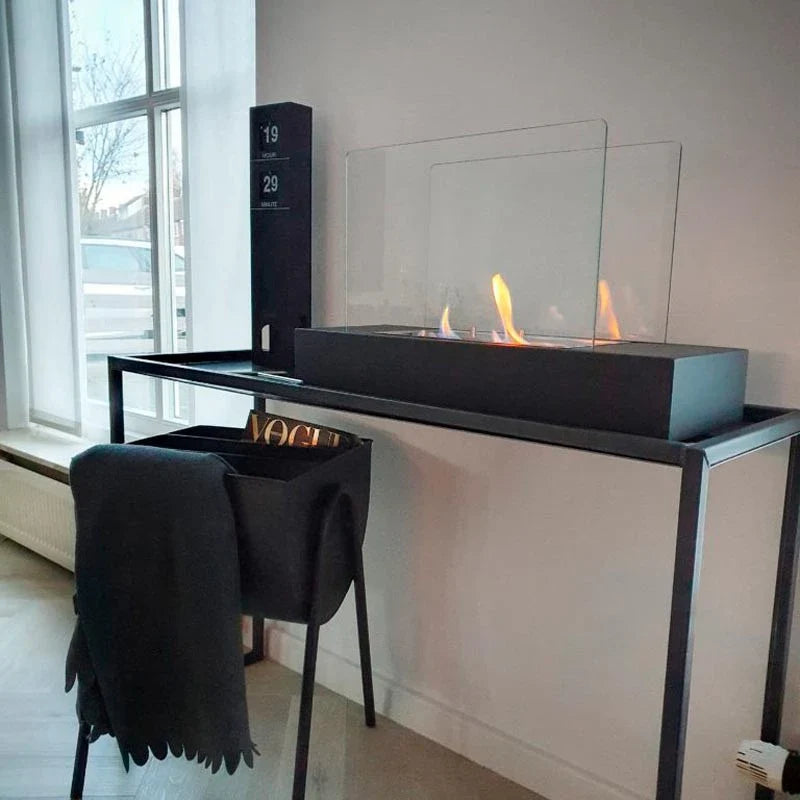 ScandiFlames Oklahoma bioethanol fireplace lit on a black console table by a window