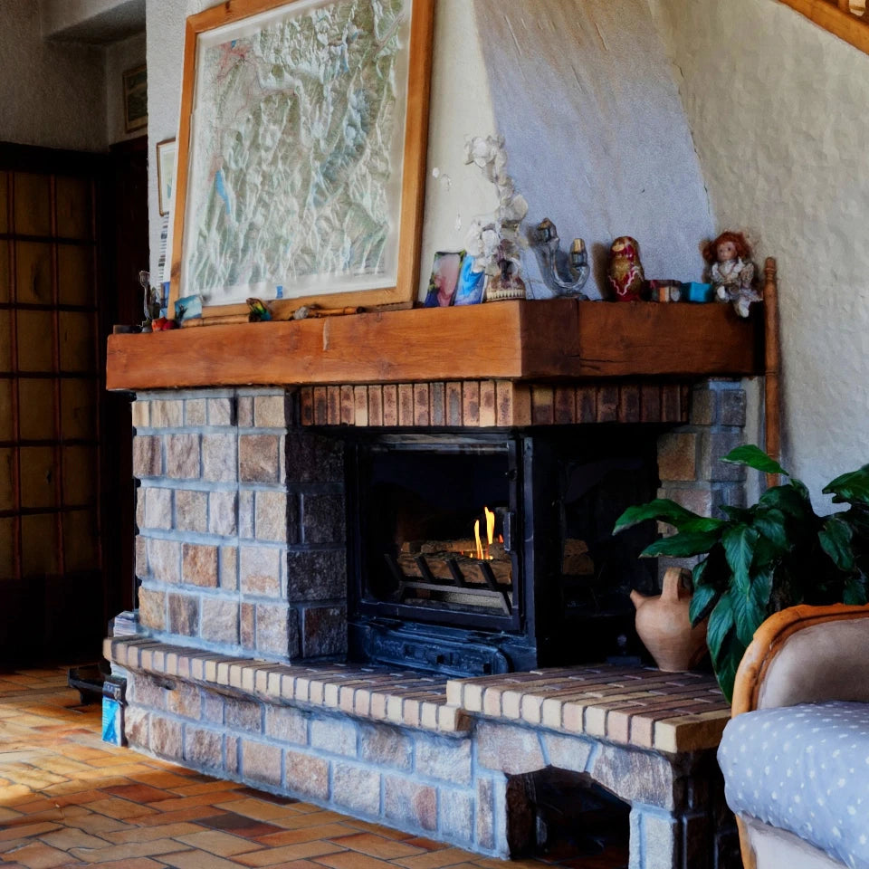 Grate M bioethanol fire insert lit inside a real stone fireplace with a wooden mantel