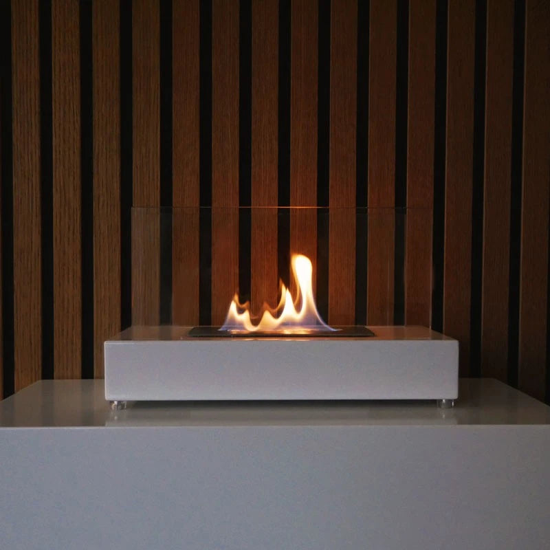 Lambeth white bioethanol fireplace lit against a wood-slat wall background