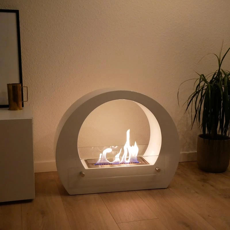 Dallas White freestanding bio fireplace on a wooden floor with a potted plant, lit realistic flame in the evening