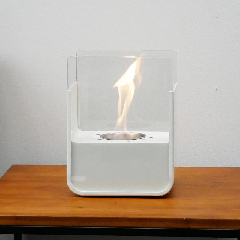 ScandiFlames small white tabletop bioethanol fireplace lit on a wooden table against a plain wall
