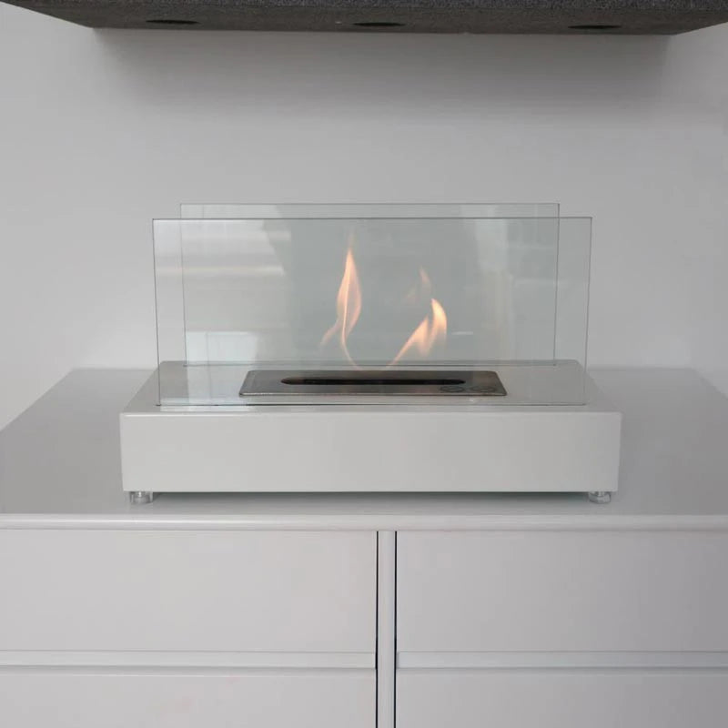 Lambeth white bioethanol fireplace lit on a minimalist white cabinet