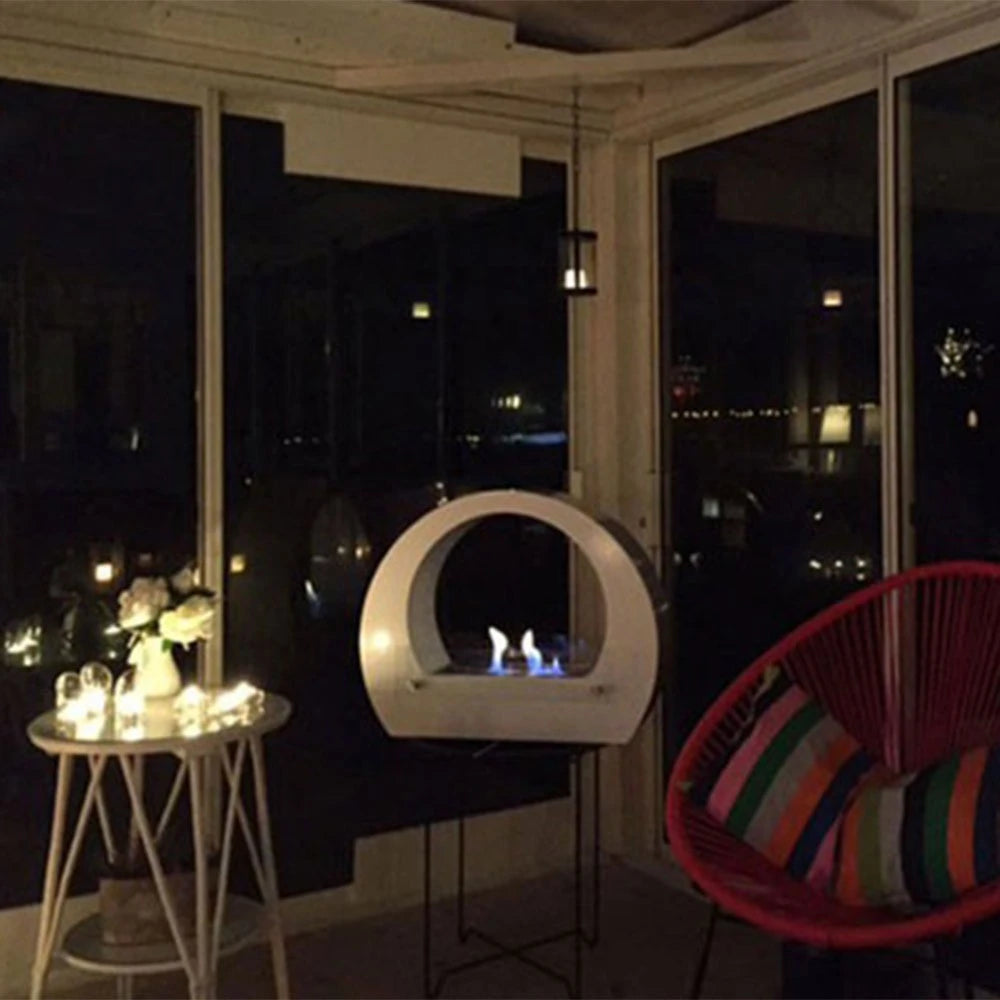 Dallas White freestanding bio fireplace on an evening balcony with a colourful woven chair, lit realistic flame