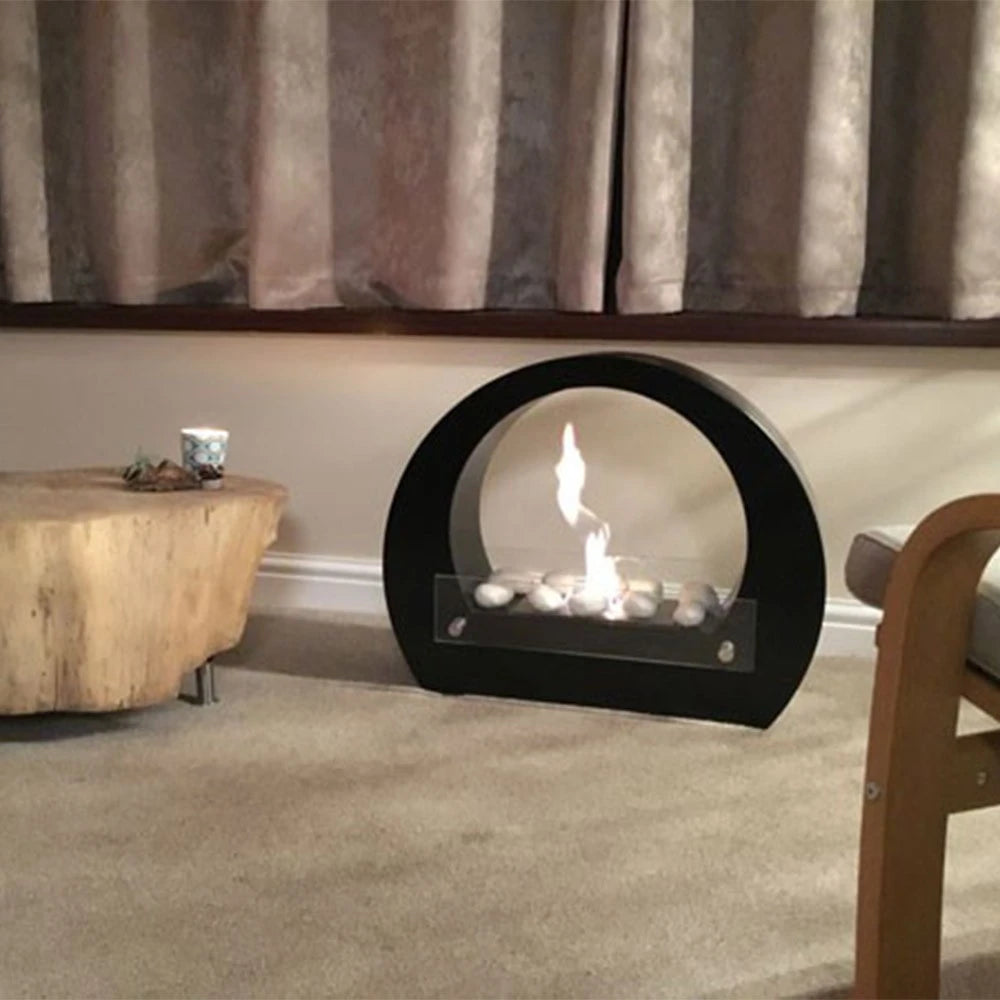 Dallas Black round bio fireplace in a real customer's living room with decorative pebbles, lit with a realistic flame