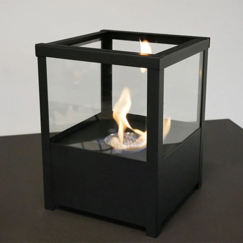 Square black tabletop bioethanol fireplace, lit, close-up studio shot showing the flame