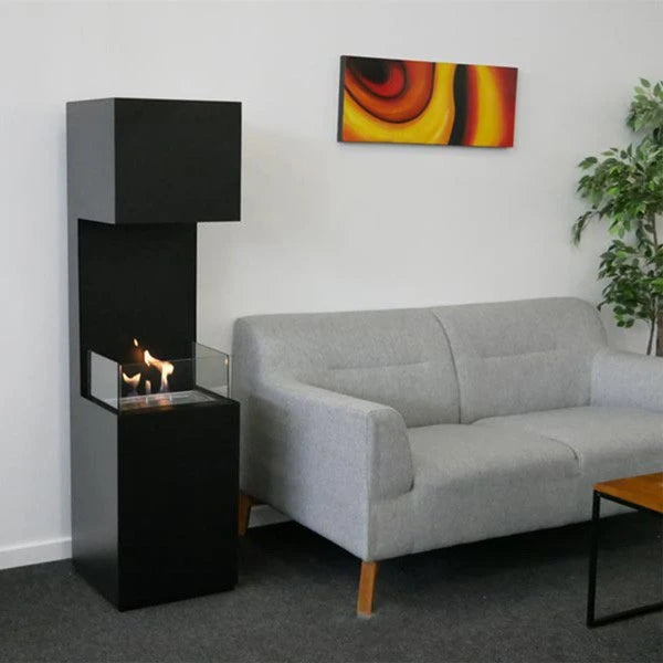 Open 3-Sided black bioethanol fireplace lit in a living room beside a grey sofa