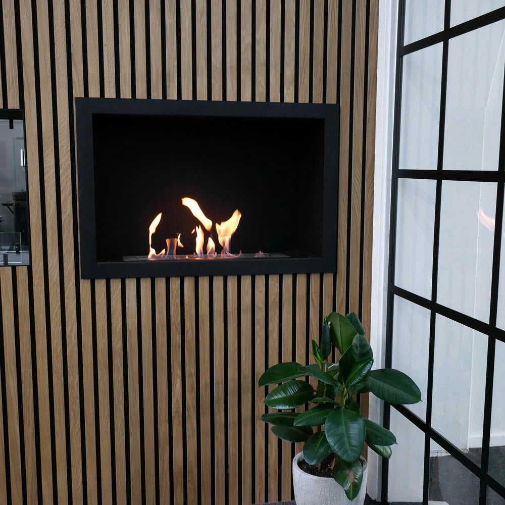 Foco One 800 built into a light oak wood-slat wall with a lit flame, close-up with potted plant