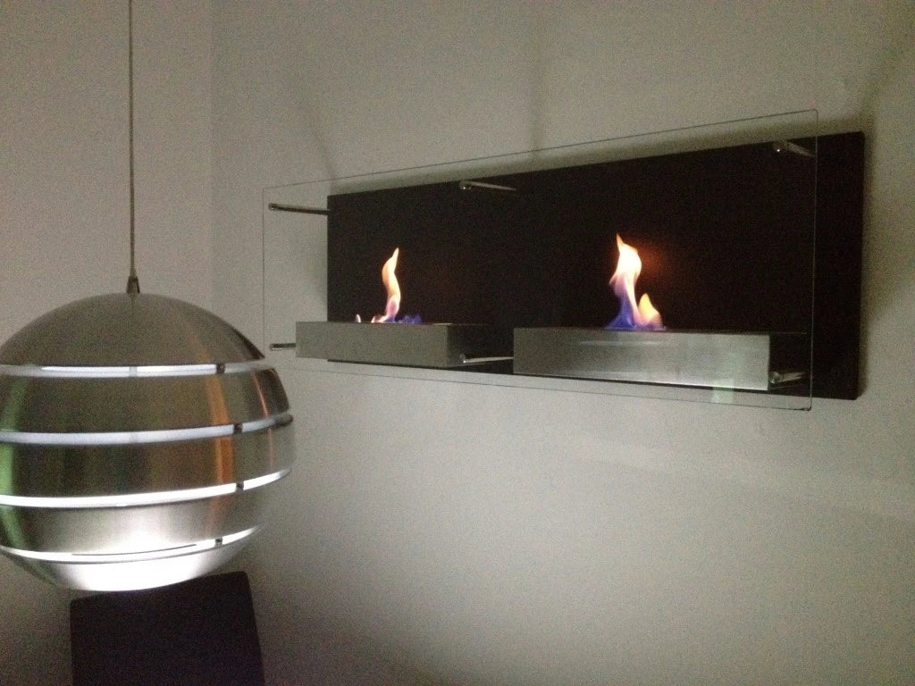 Double Nevada bioethanol wall-mounted fireplace with lit flames, mounted on a wall beside a spherical pendant lamp in a dimly lit room