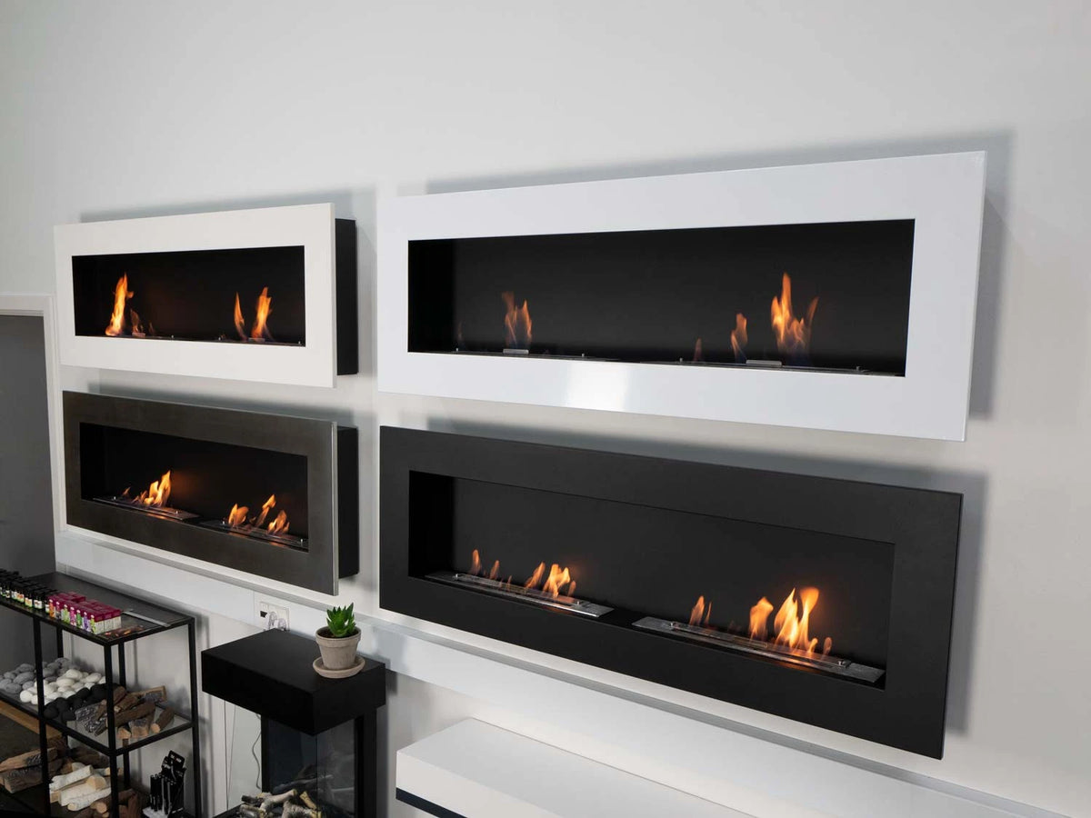 Four Murus wall-mounted bio fireplaces in white, black and brushed steel finishes displayed together, lit