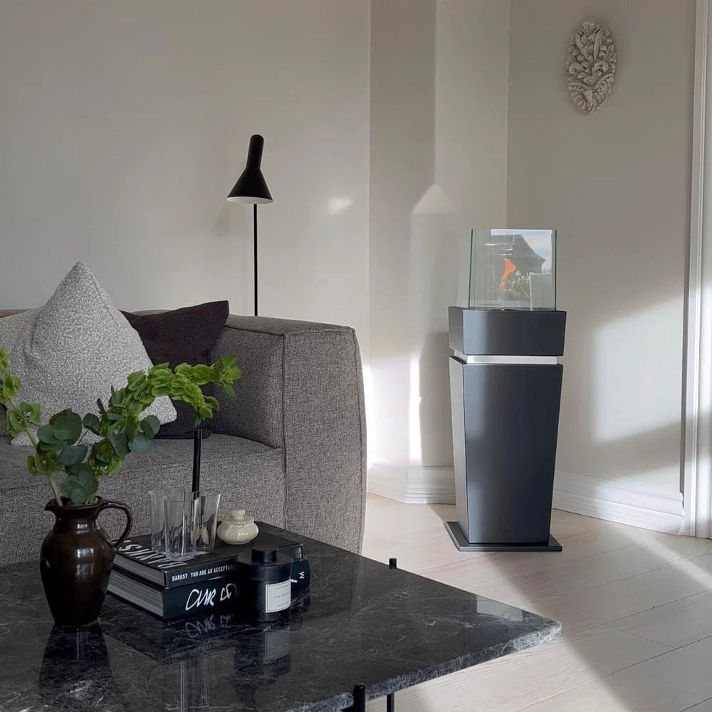 Elegant black bioethanol fireplace lit in a real living room corner