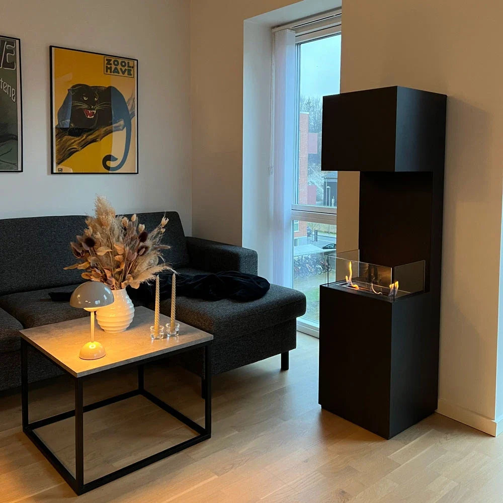 ScandiFlames Open 3-Sided bio fireplace lit in a cozy living room beside a sofa and coffee table