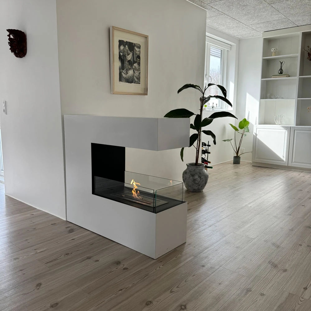 Topeka White bio fireplace built into a room-divider wall in a real living room, lit with a realistic flame