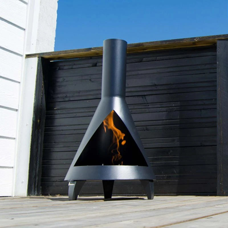 ScandiFlames Salem bioethanol fireplace lit outdoors on a sunny deck against a dark wood fence