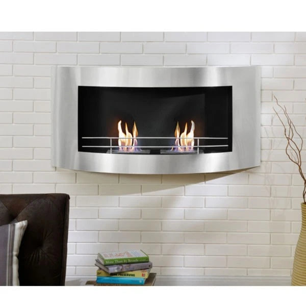 Curved stainless steel wall-mounted bioethanol fireplace lit on a white brick wall above a dark sofa, close view